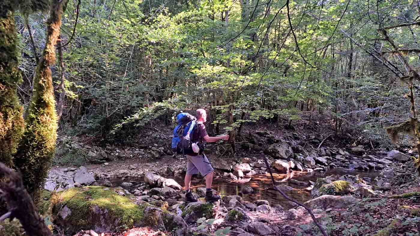 Etapa 7: Refugio Sant Miquel de Bassegoda - Beget. Transpirenaica GR11. 2 Senderista junto a un arroyo