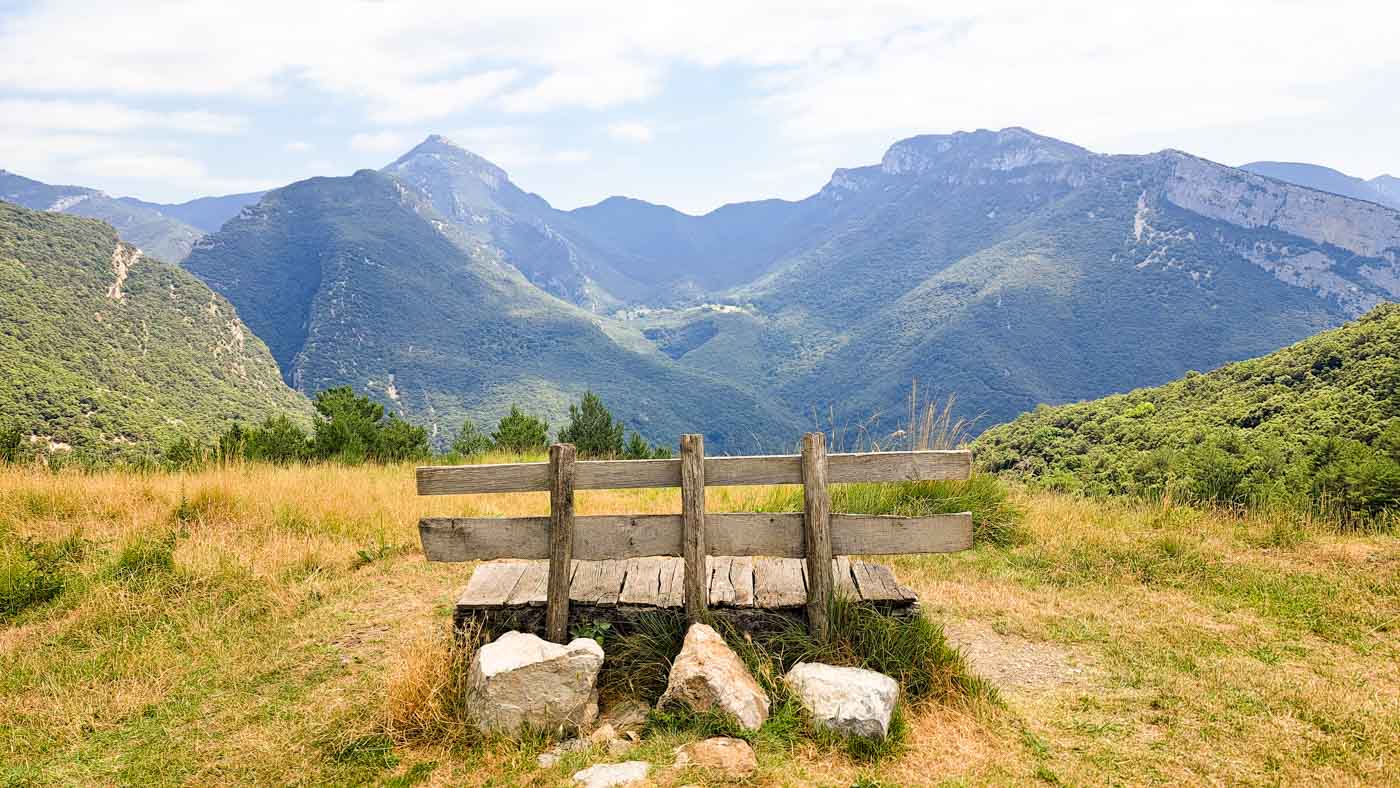 Etapa 7: Refugio Sant Miquel de Bassegoda - Beget. Transpirenaica GR11. 1 Banco de madera con vista montañosa