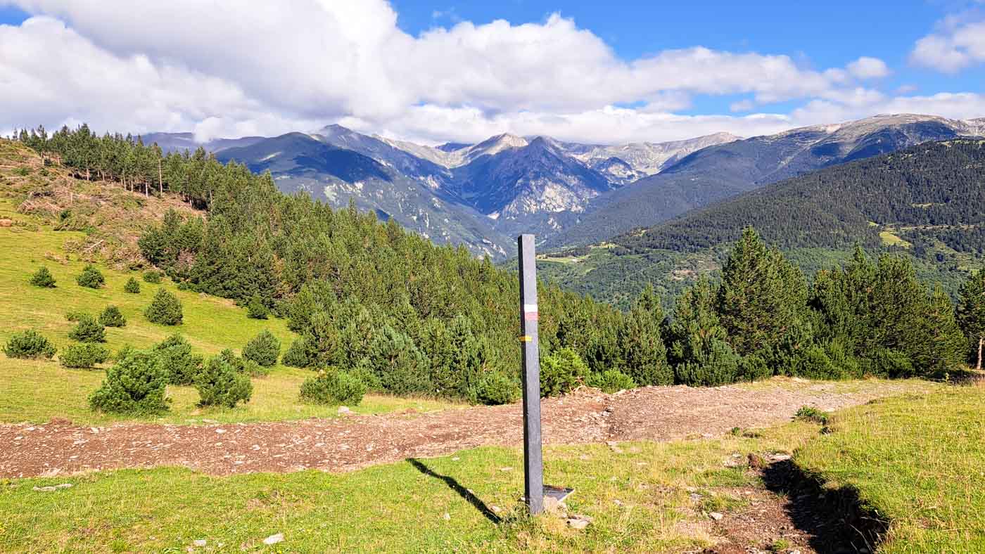 Etapa 9: Molló - Cabaña de Tirapits. Transpirenaica GR11. 4 Poste indicativo delante de bosques y montañas