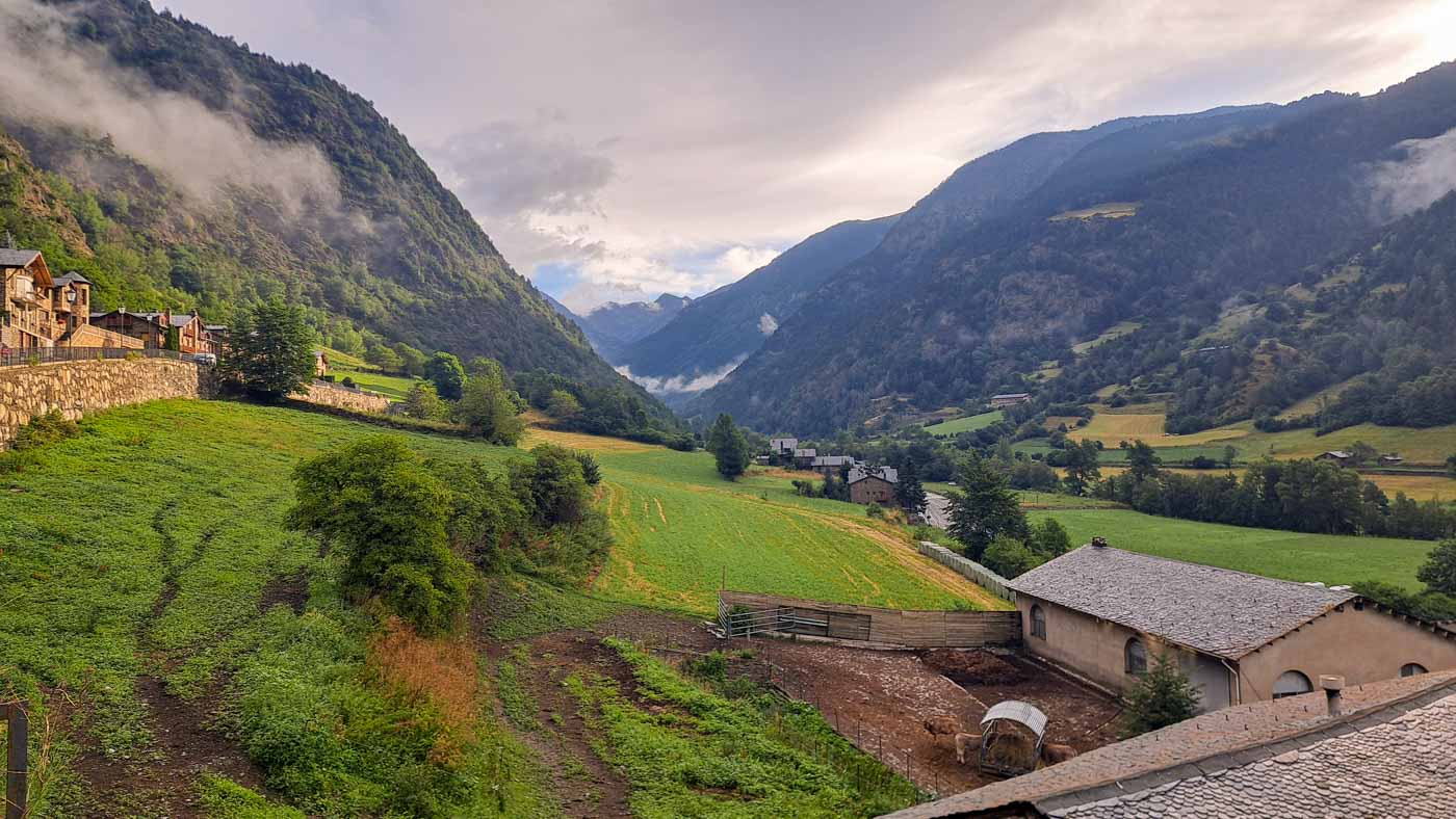 Etapas de la Transpirenaica GR11 en Andorra 3 Valle profundo con bosques y unos techos de una ganadería