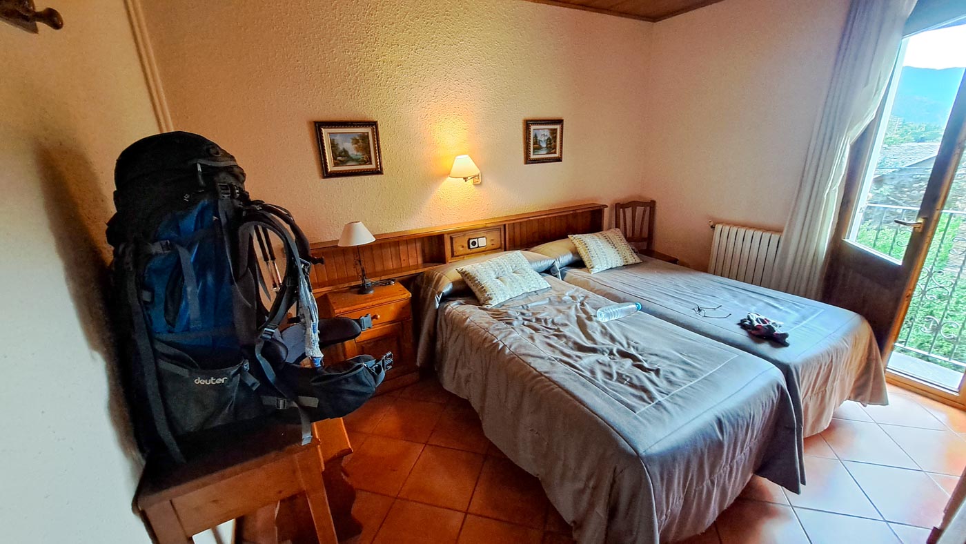 Etapa 21: Refugio Colomers - Boí. Transpirenaica GR11. 5 foto de habitación de hotel con dos camas, ventana y mochila