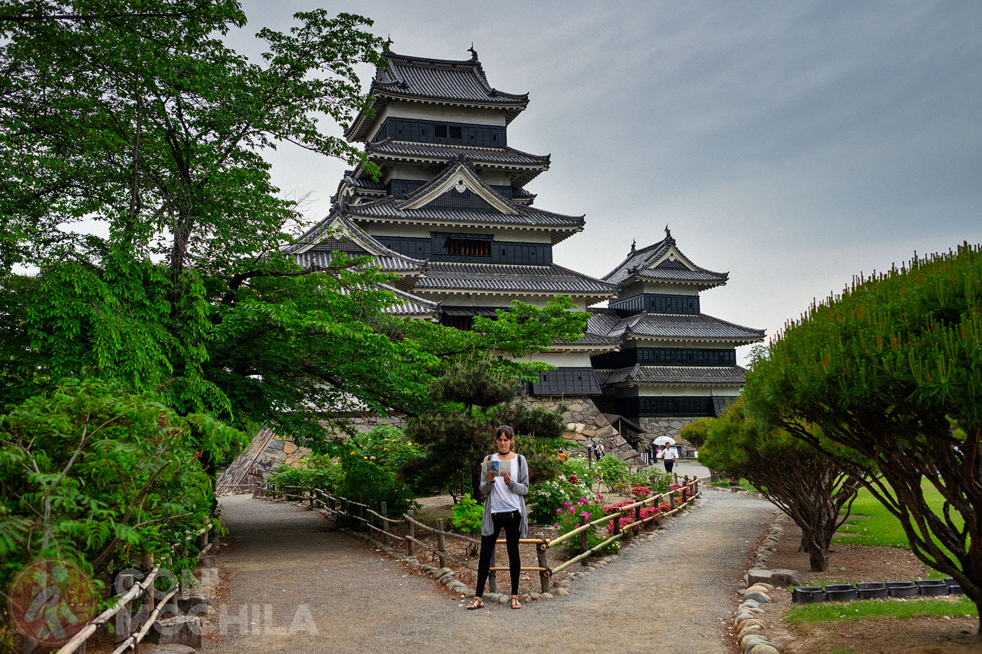 A tourist reading a guide about Matsumoto Castle