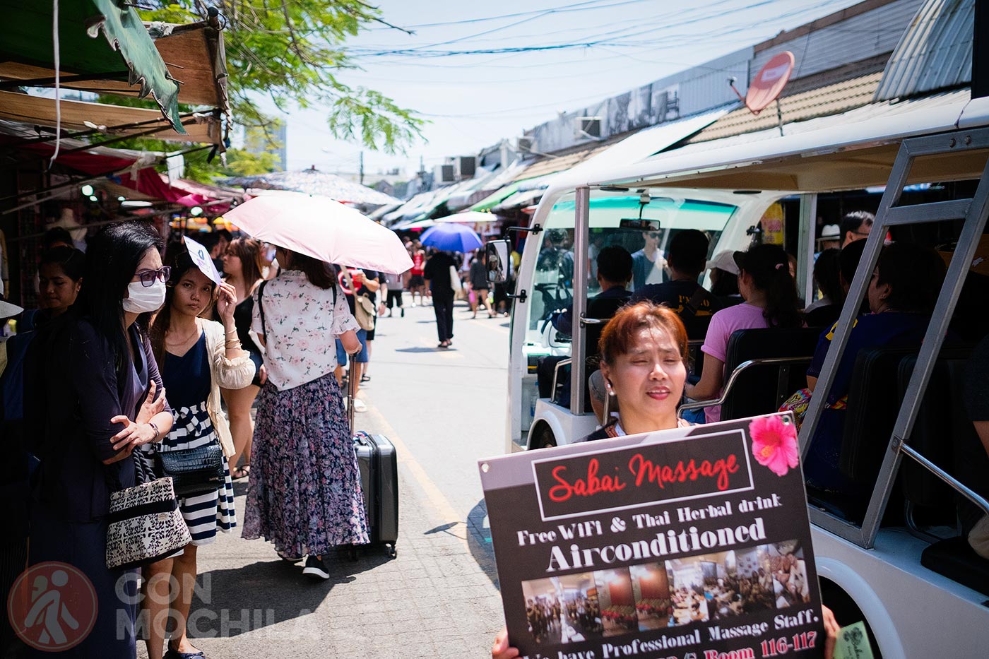 A vendor offering Thai massages and herbal drinks in a shop with Wi-Fi and air conditioning