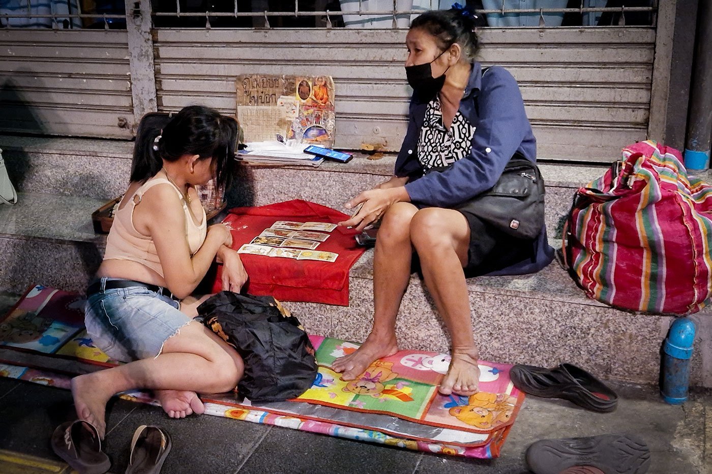 A tarot reader reads cards on the street of a red-light district