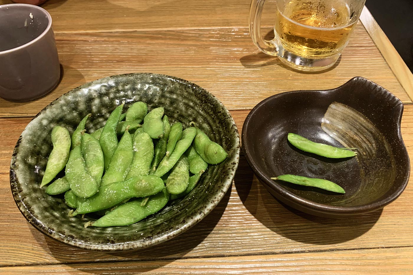 Portion of eda mame, with its bowl to throw the empty shells in