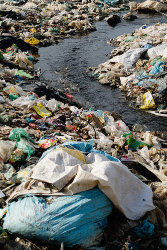 Riachuelo de agua negra entre la basura