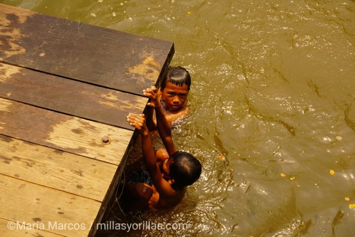Niños camboianos dandose un baño mientras sus padres venden a los turistas.
