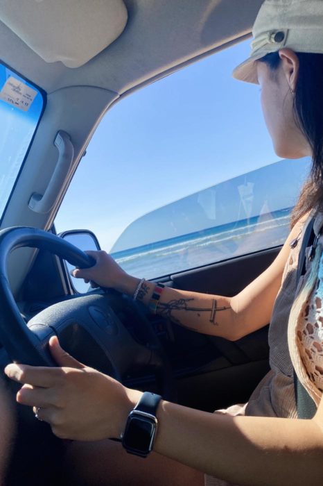 Thea conduciendo por la playa