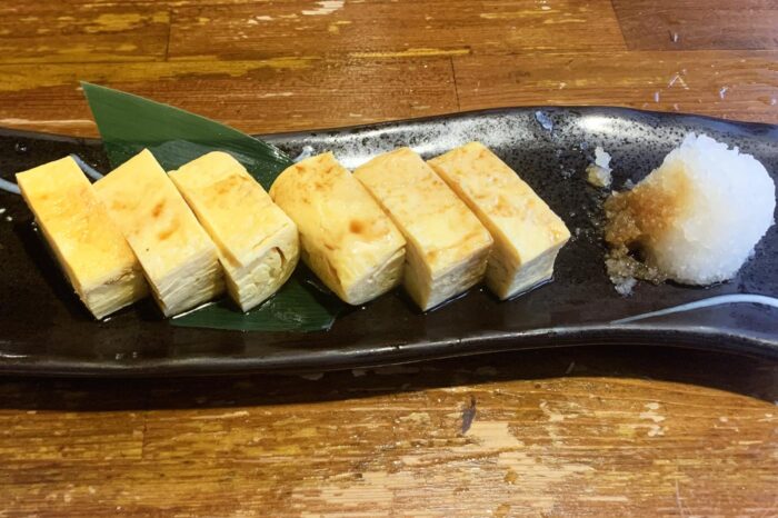 Ración de tamago-yaki tal y como se sirve en las tabernas izakaya: cortada en pequeños bocados y con nabo rallado y salsa de soja para acompañar
