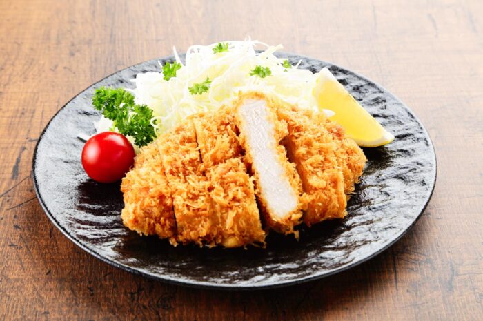 Filete de tonkatsu, cortado en tiras y acompañado de su guarnición habitual de col rallada