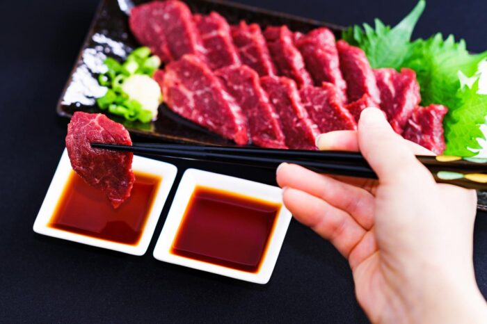 Finos cortes de basashi, carne de caballo cruda, servidos como si fueran sushi