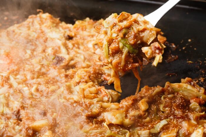 Eso de desparramar la masa sobre la plancha para luego ir rascándola poco a poco hace del monja-yaki un asunto algo pringoso, pero muy divertido 