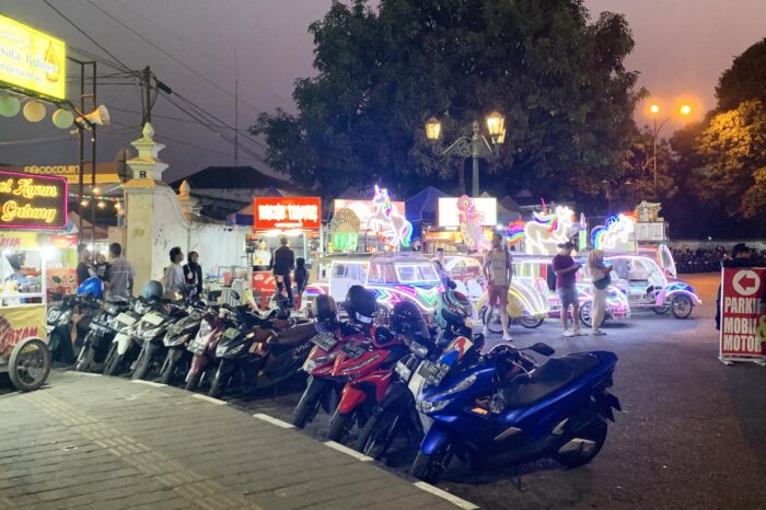 Ambientillo nocturno: autos de choque con neones y puestos de comida callejera