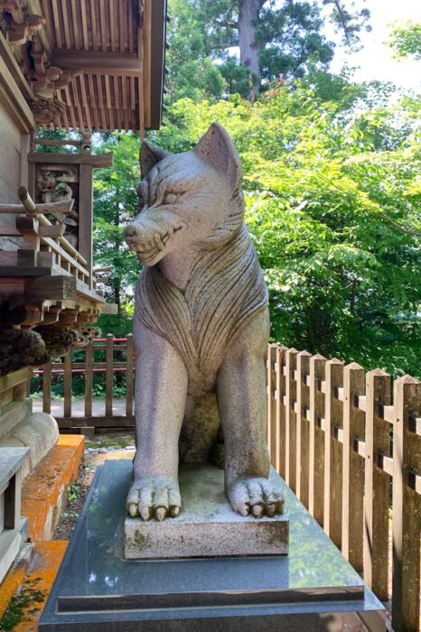 Estatua de un dios lobo, guardando la entrada de un santuario sintoísta en las montañas
