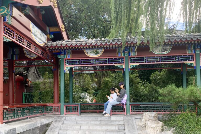 Una estampa muy china: madre e hija revisando el móvil en un parque de Pekín