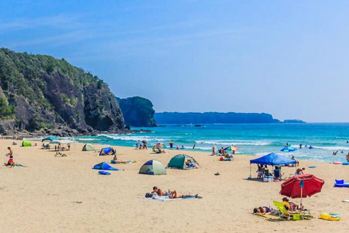 Panorámica de una playa en Izu, llena de sombrillas y parapetos para esquivar el sol